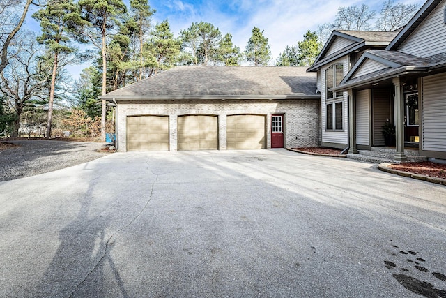 7016 Hyde Park Rd, Whitehall, MI 49461 - view of side of home with an attached garage, driveway, and a shingled roof
