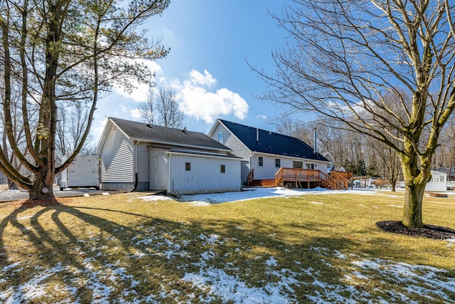 snow covered back of property featuring a yard and a wooden deck