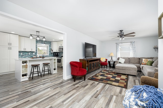 living room featuring light wood-type flooring and ceiling fan