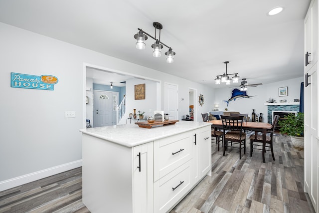 kitchen featuring pendant lighting, white cabinetry, baseboards, and wood finished floors