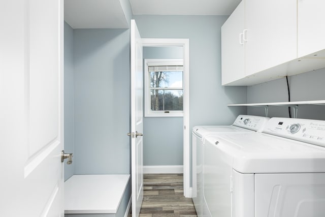 clothes washing area featuring washing machine and clothes dryer, wood finished floors, cabinet space, and baseboards