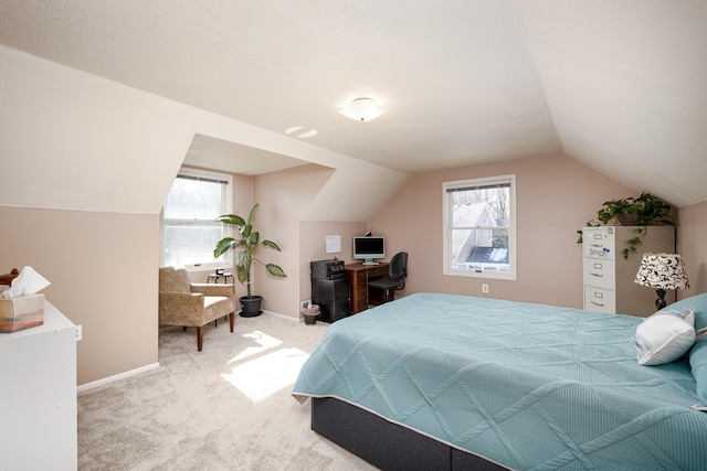 carpeted bedroom with lofted ceiling, multiple windows, and baseboards