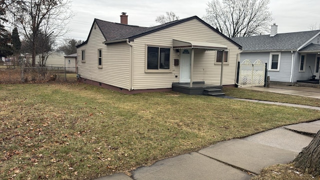 bungalow-style house with a shingled roof, a front yard, crawl space, and fence