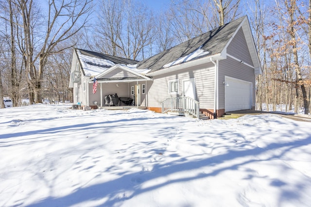 snow covered property featuring a garage