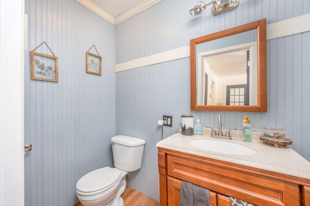 bathroom featuring toilet, crown molding, and vanity