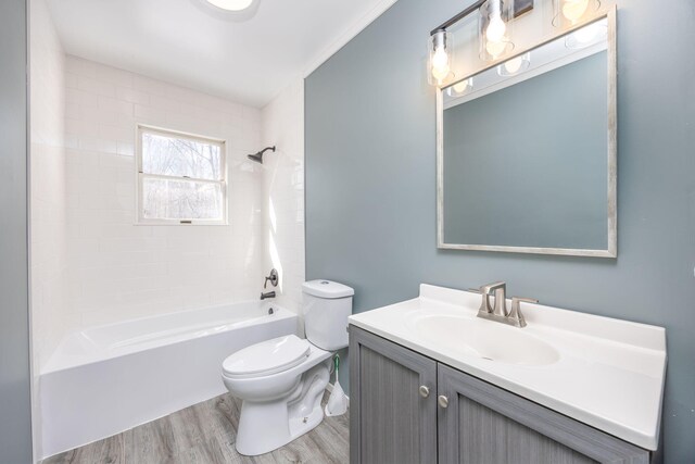 bathroom featuring toilet, shower / washtub combination, wood finished floors, and vanity