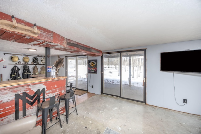 bar featuring concrete flooring and a textured ceiling