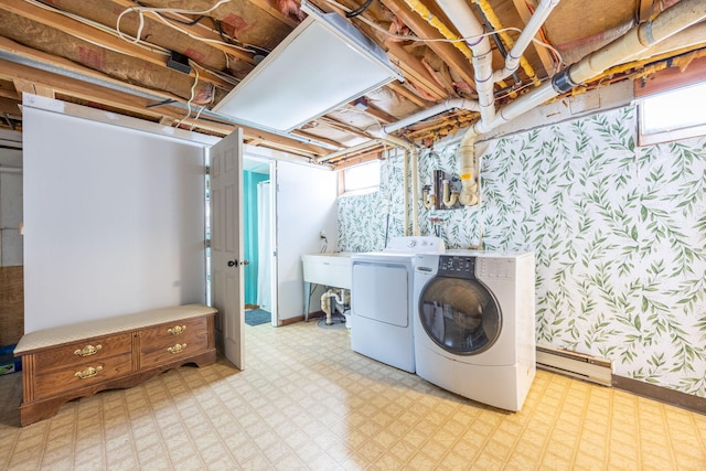 clothes washing area featuring laundry area, baseboard heating, light floors, washing machine and clothes dryer, and wallpapered walls