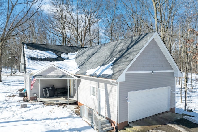 view of snow covered exterior with a garage