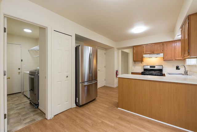 3048 Turnberry Ln, Ann Arbor, MI 48108 - kitchen with stainless steel appliances, a sink, under cabinet range hood, a peninsula, and light countertops