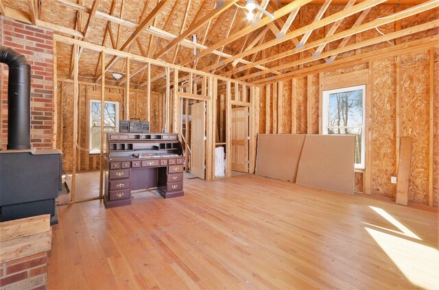 11333 Stony Creek Rd, Milan, MI 48160 - basement featuring a wood stove, plenty of natural light, and wood finished floors