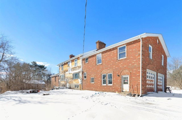 11333 Stony Creek Rd, Milan, MI 48160 - snow covered house featuring an attached garage, a chimney, and brick siding
