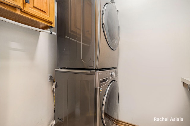 laundry room featuring cabinet space and stacked washer / drying machine