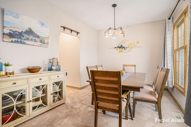 dining area with light colored carpet, visible vents, and baseboards