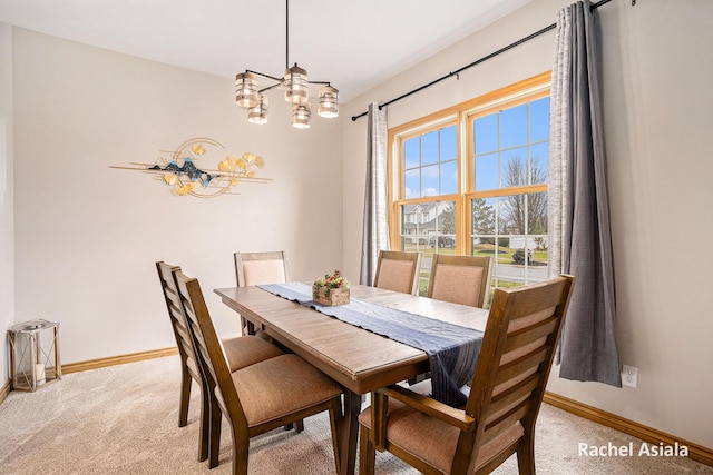 dining space featuring light carpet, baseboards, and a notable chandelier