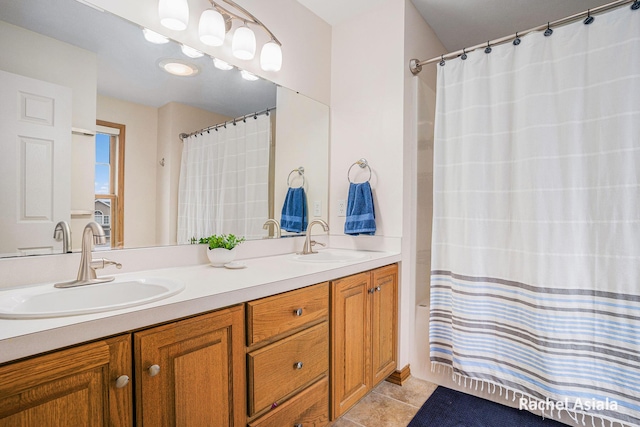 bathroom featuring double vanity, curtained shower, tile patterned flooring, and a sink