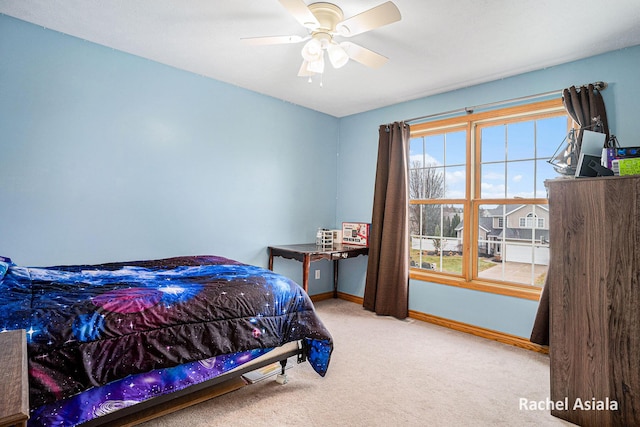 carpeted bedroom with baseboards and a ceiling fan