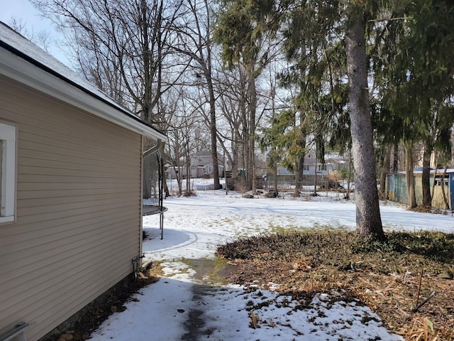 yard covered in snow with a trampoline