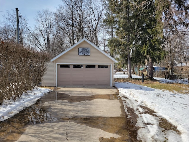 snow covered garage with a detached garage