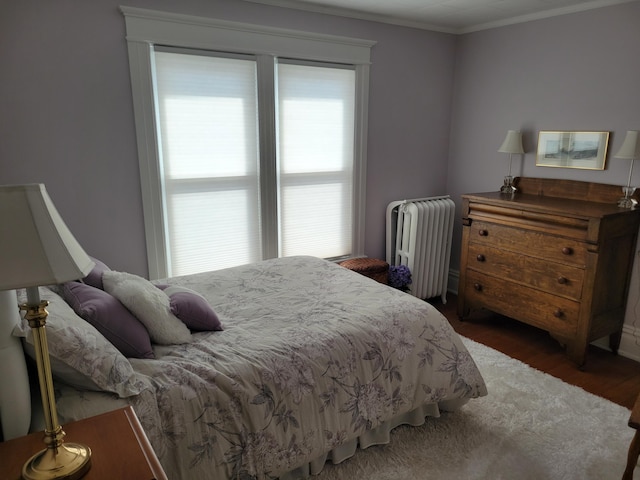 bedroom featuring ornamental molding, dark wood-type flooring, and radiator