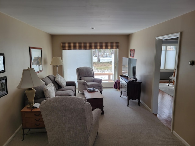 living area with light carpet and baseboards