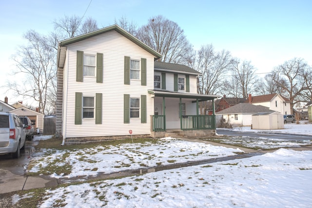 view of front facade with an outbuilding, covered porch, and a shed