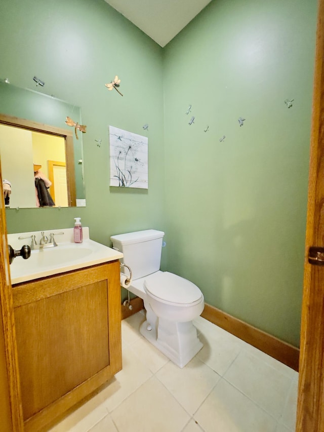 half bath featuring baseboards, vanity, toilet, and tile patterned floors