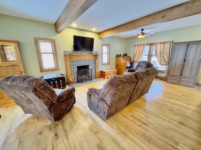 living area with a healthy amount of sunlight, light wood finished floors, and beam ceiling