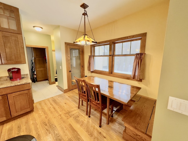 dining space featuring light wood finished floors and baseboards