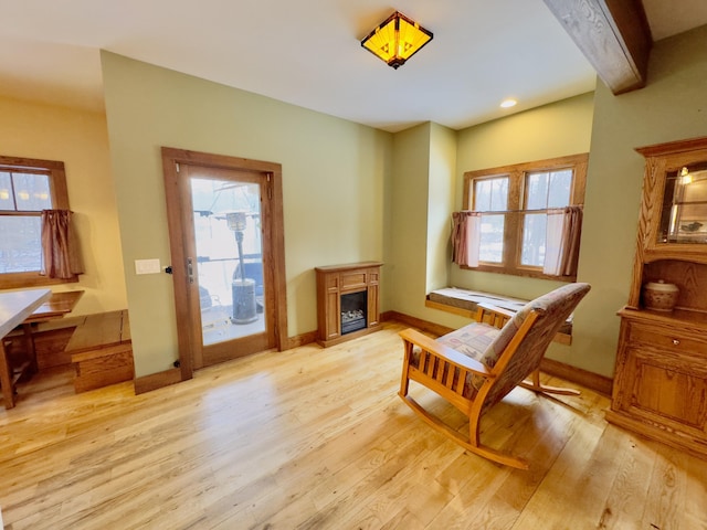 living area with light wood finished floors, a fireplace, baseboards, and recessed lighting