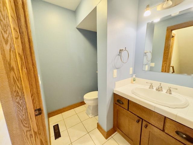 bathroom with visible vents, toilet, vanity, tile patterned flooring, and baseboards