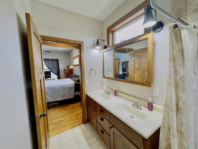 ensuite bathroom with a sink, double vanity, connected bathroom, and tile patterned floors