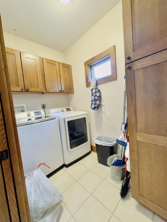 laundry area featuring light tile patterned floors, cabinet space, and washer and dryer