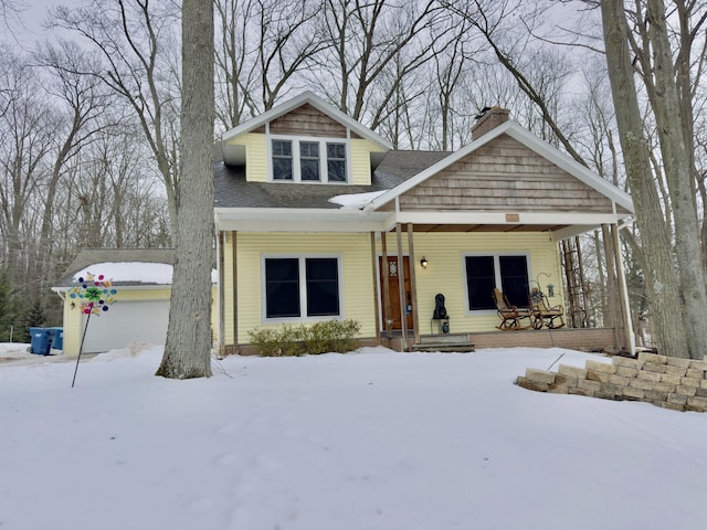 view of front of home featuring a porch, a shingled roof, and a chimney