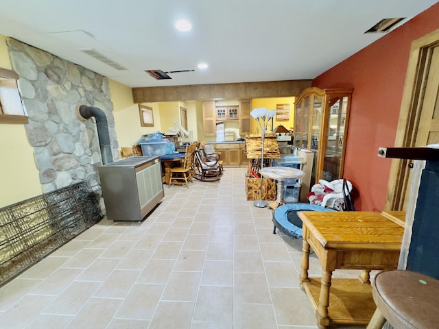 interior space with recessed lighting, a wood stove, visible vents, and light tile patterned floors