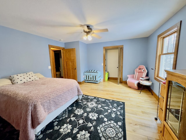 bedroom with a ceiling fan, baseboards, and wood finished floors