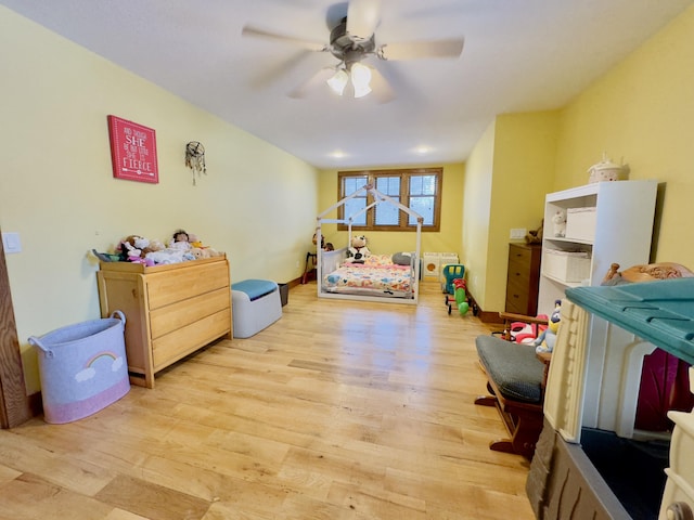 bedroom with light wood-style floors, baseboards, and a ceiling fan