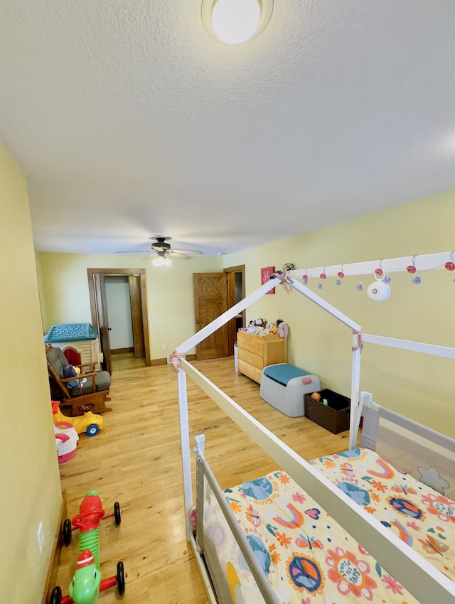 bedroom with a textured ceiling and wood finished floors