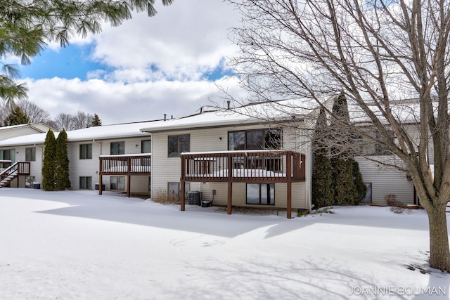 snow covered rear of property featuring a deck