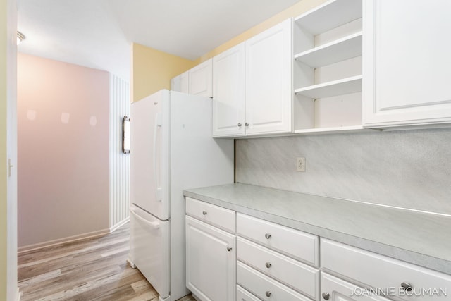 kitchen with white cabinetry, light wood-style floors, light countertops, freestanding refrigerator, and open shelves