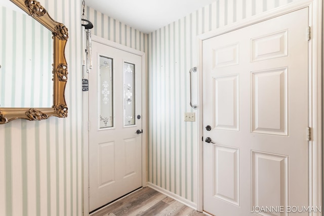 foyer entrance with light wood-style flooring and wallpapered walls