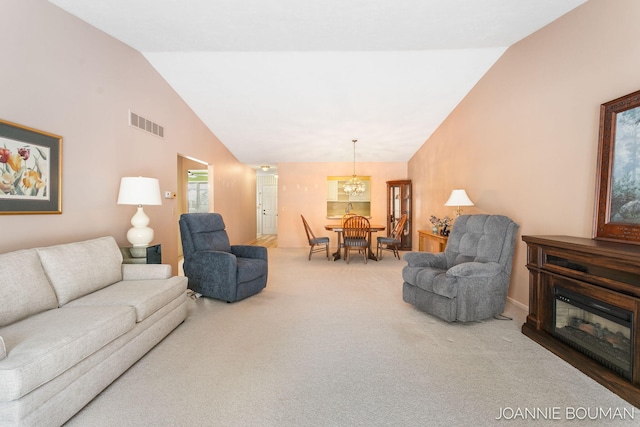 living room featuring visible vents, a chandelier, a glass covered fireplace, carpet, and high vaulted ceiling