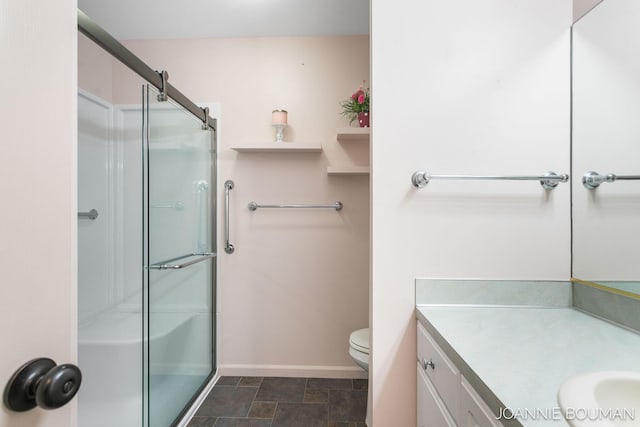 bathroom featuring toilet, a shower stall, vanity, and baseboards