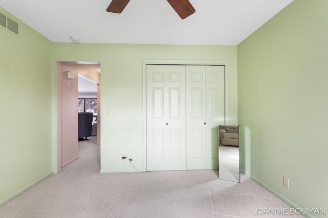 unfurnished bedroom with carpet floors, baseboards, visible vents, and a closet