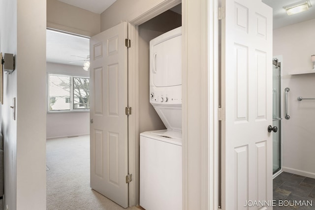 laundry room featuring laundry area, carpet floors, stacked washer / dryer, a ceiling fan, and baseboards