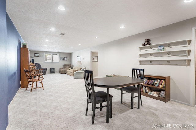 dining area with carpet, a textured ceiling, and recessed lighting