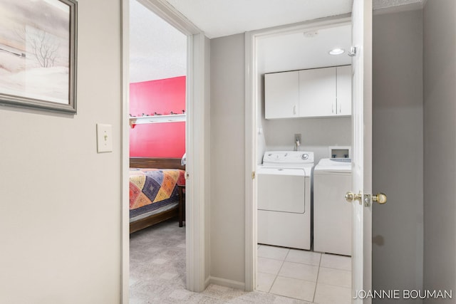 washroom featuring light colored carpet, cabinet space, independent washer and dryer, and light tile patterned flooring