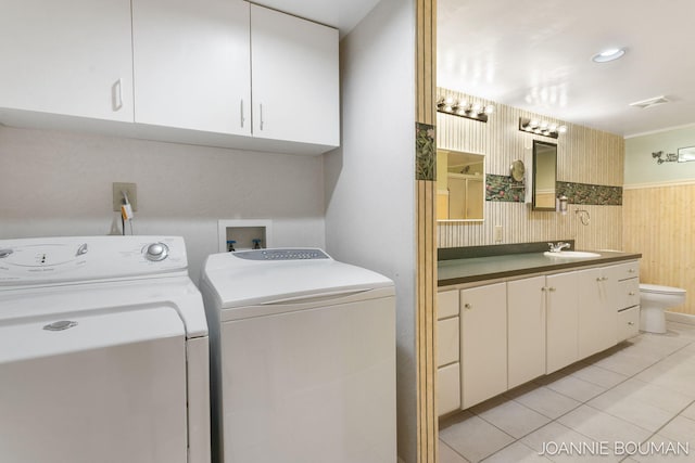 laundry area with light tile patterned floors, a sink, visible vents, cabinet space, and washing machine and clothes dryer