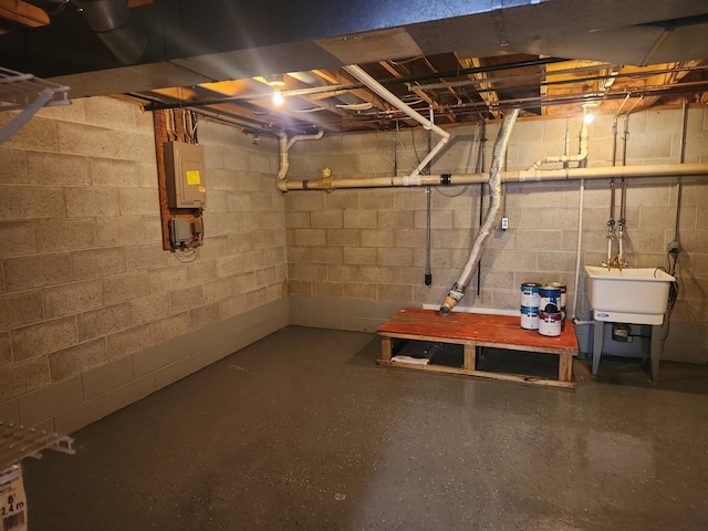 unfinished basement featuring a sink and electric panel