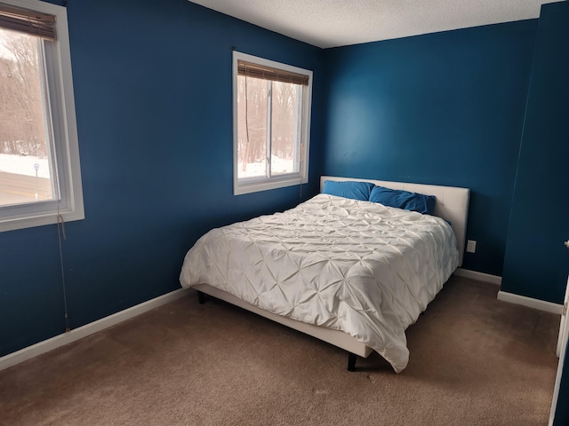 bedroom featuring a textured ceiling, carpet flooring, and baseboards